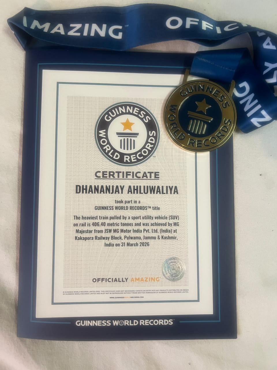 Guinness World Records certificate and medal awarded to Dhananjay Ahluwaliya for the MG Majestor heaviest train pulled by an SUV record